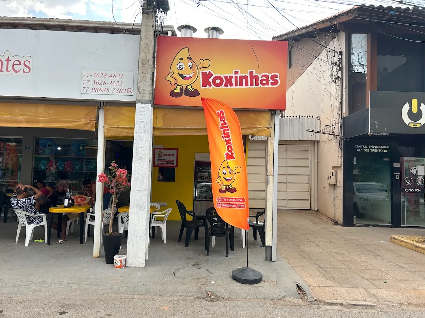 Área externa da lanchonete Koxinhas com mesas e cadeiras para os clientes